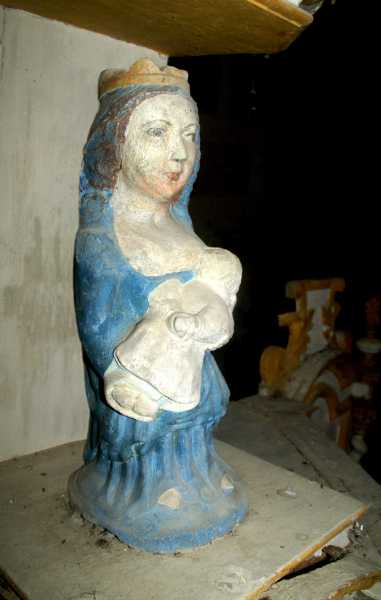 Cette Vierge pourrait être datée du XIV ou du XVème siècle. Elle appartient à 'art populaire, ce qui la fait paraître plus archaïque. Elle semble assise, mais le siège n'apparait pas. Le visage est plus grand que nature et frontal, comme celui des madones romanes. Mais le traitement des plis du manteau est bien gothique. La Vierge allaite l'enfant tenu serré contre son sein gauche dénudé. 